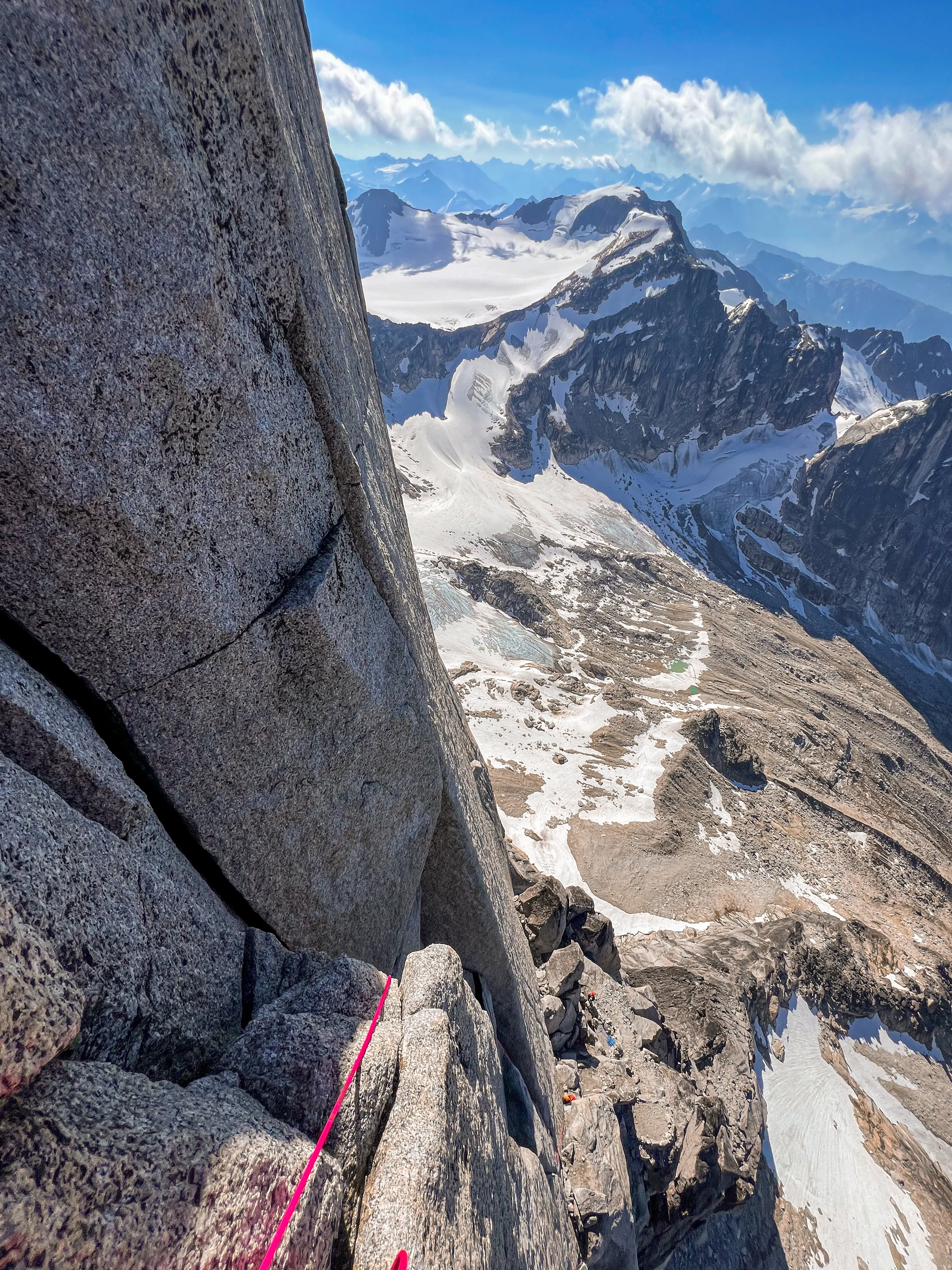 A climbing rope running down steep granite above the bivy ledge