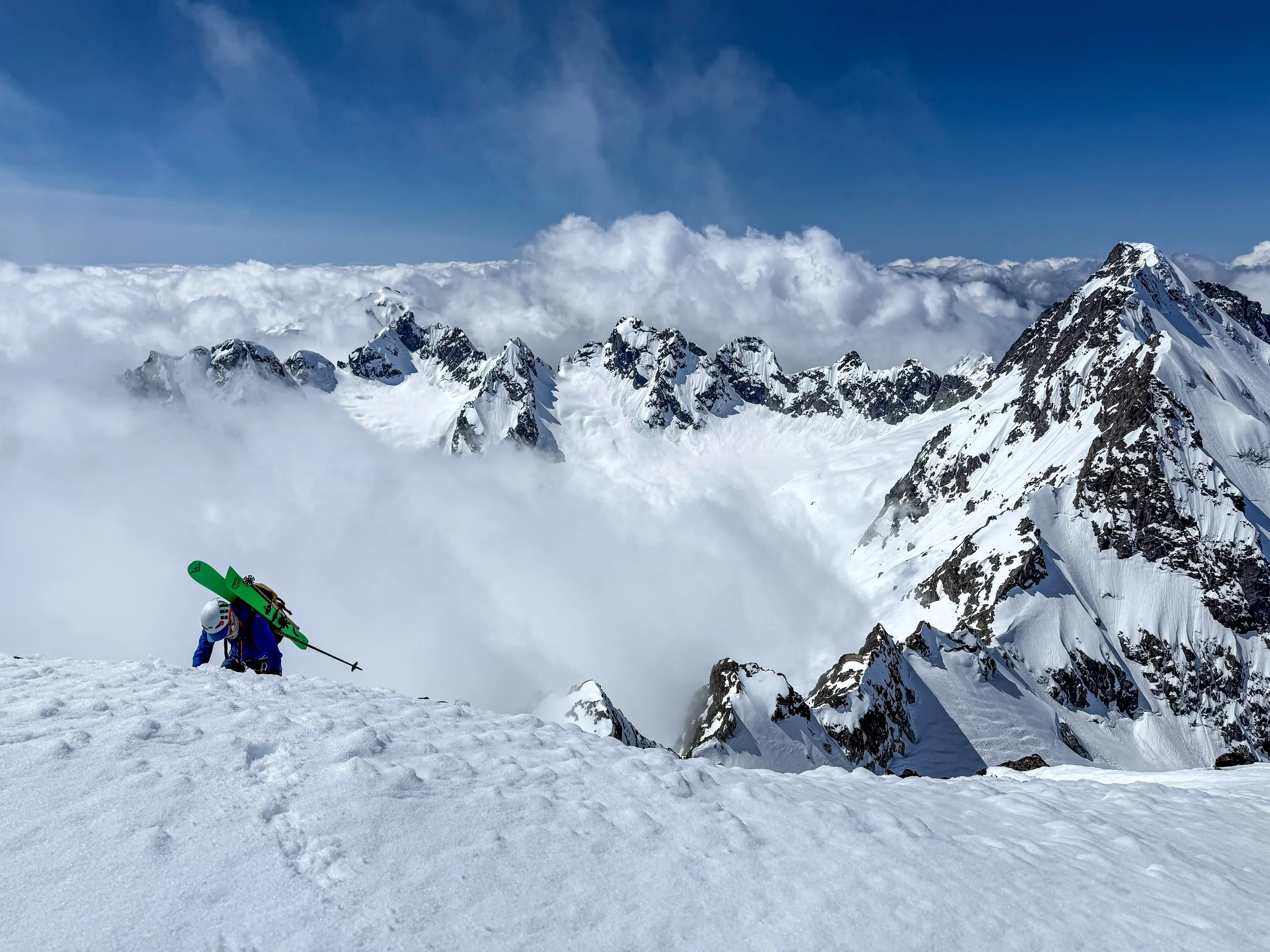 Alexis cresting the summit ridge of Alpha Mountain above an inversion in the Tantalus Range
