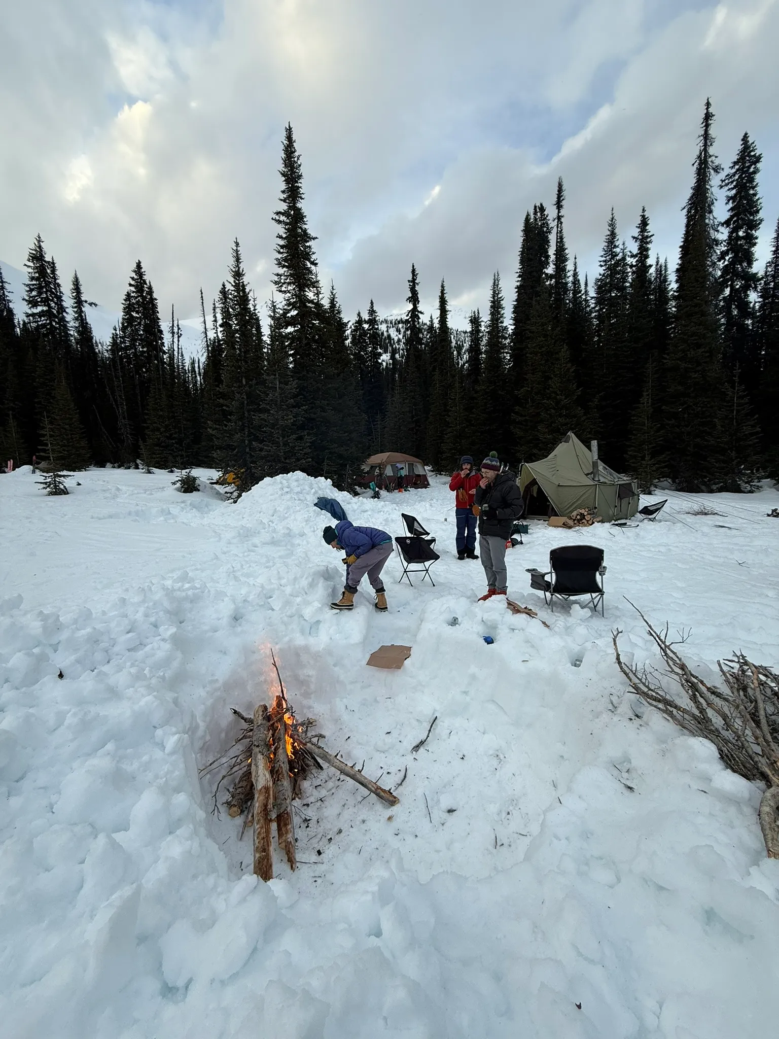 The Azure Pass group gathered around a fire dug into the snow at base camp