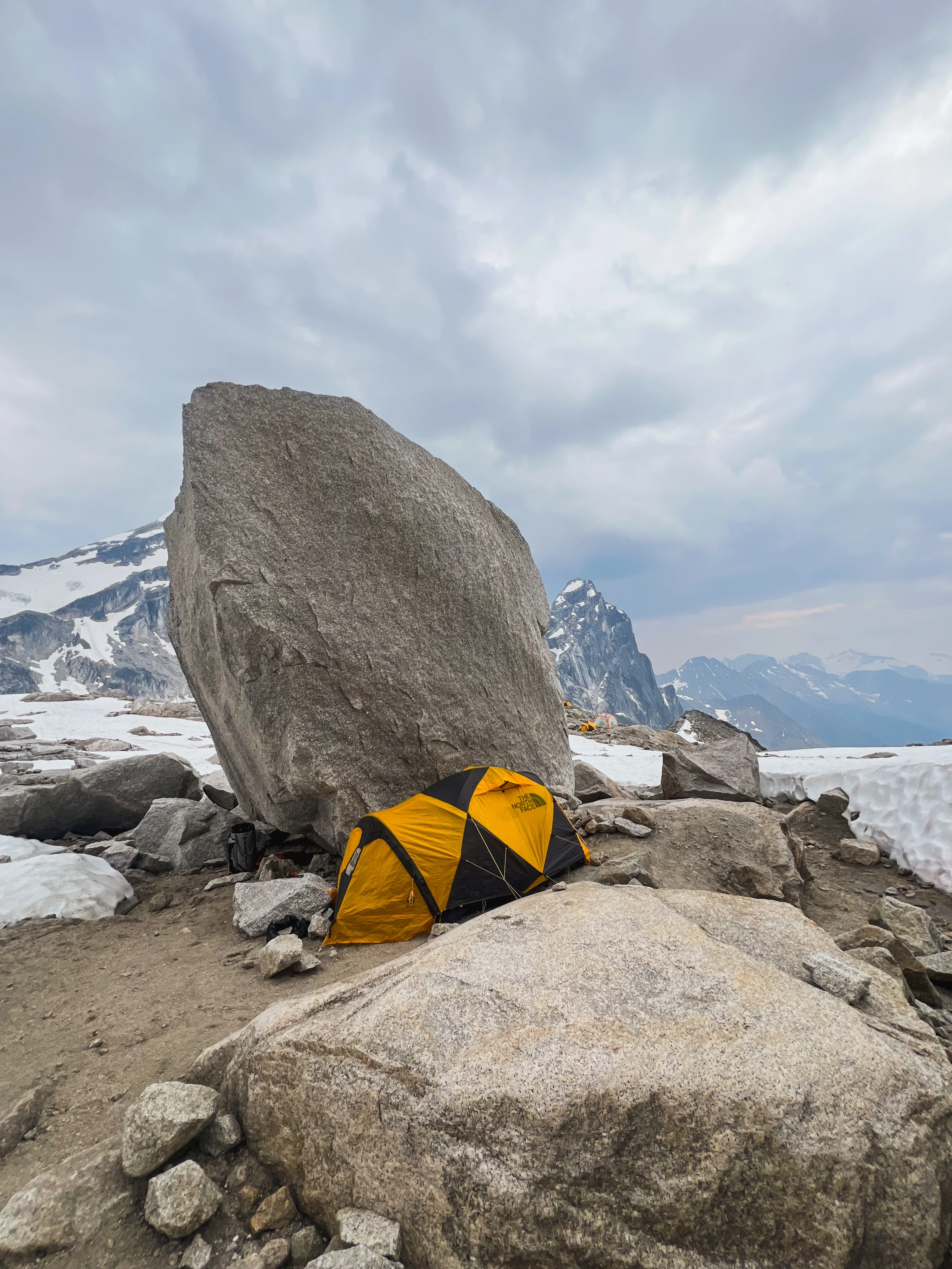 A yellow tent pitched beneath the Great Boulder at East Creek