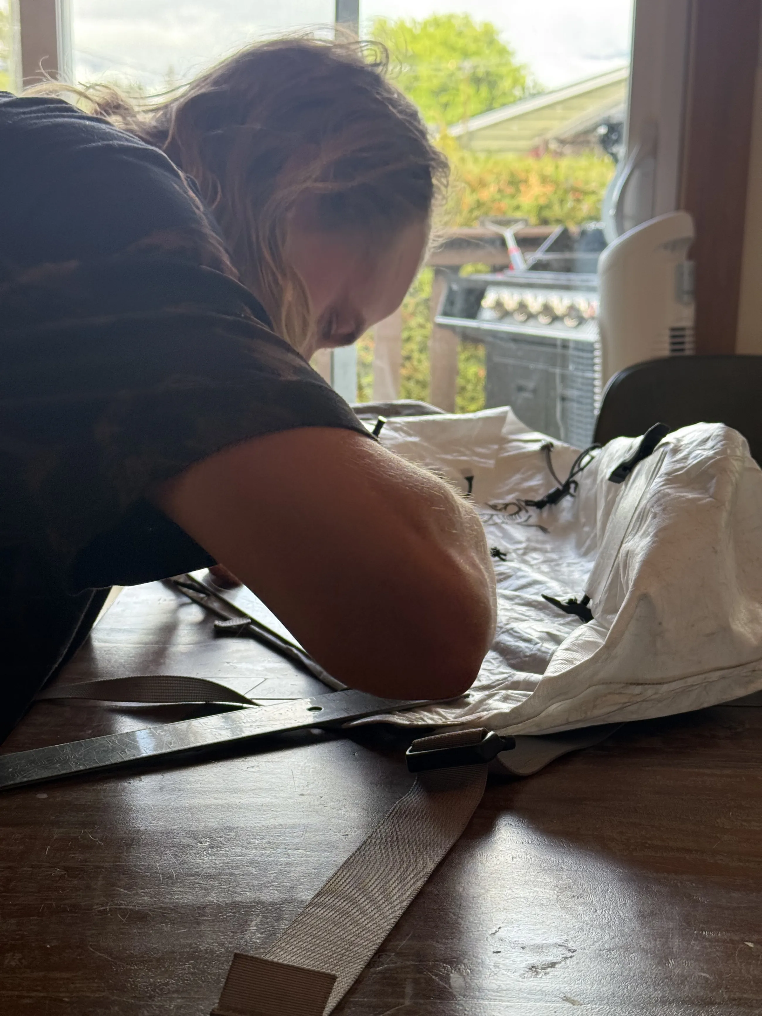James leaning over the Alpha SL 30 while working on the side-zipper modification at a kitchen table