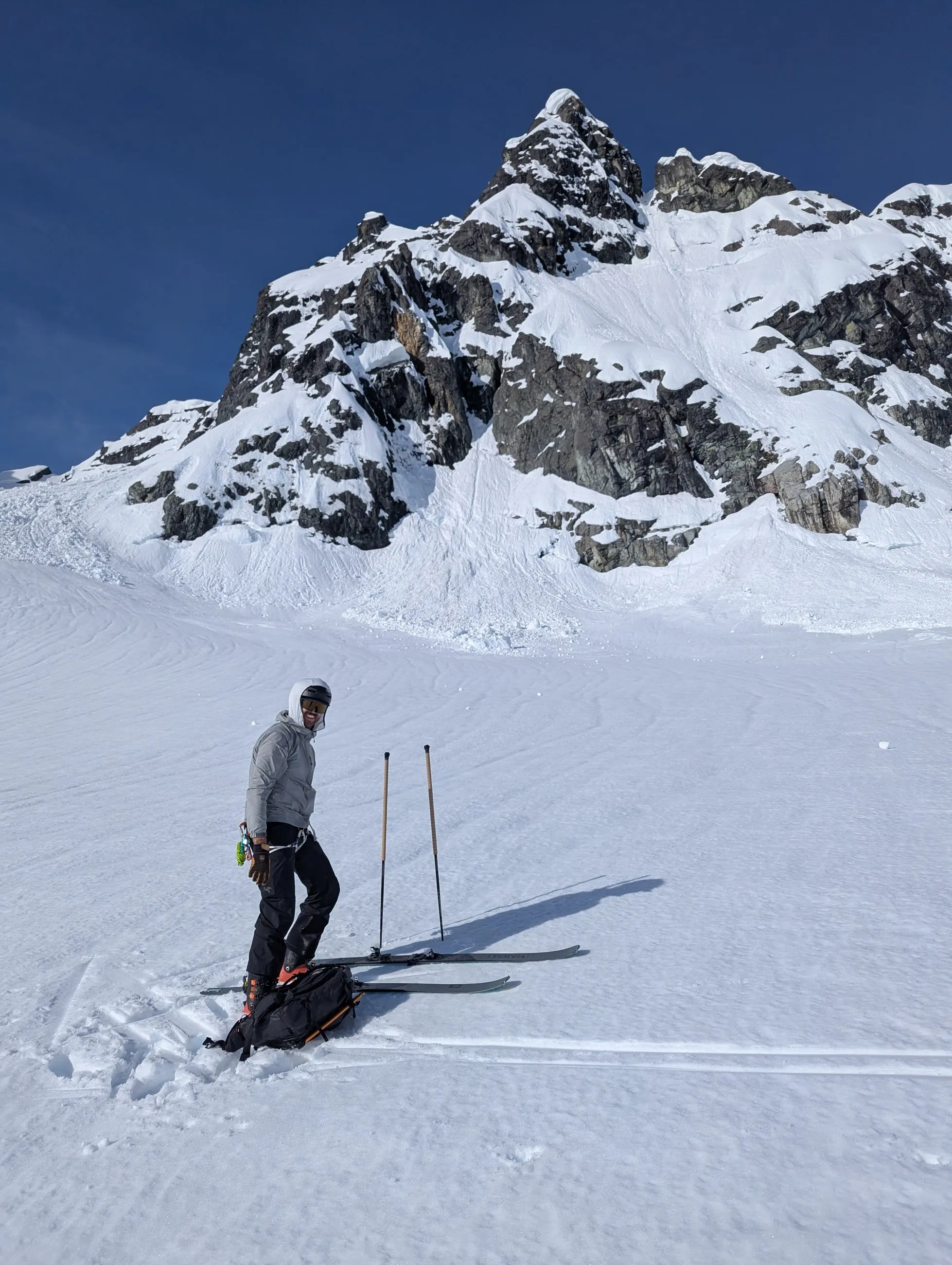 Jordan standing on skis below fresh avalanche debris on the slopes of Ionia