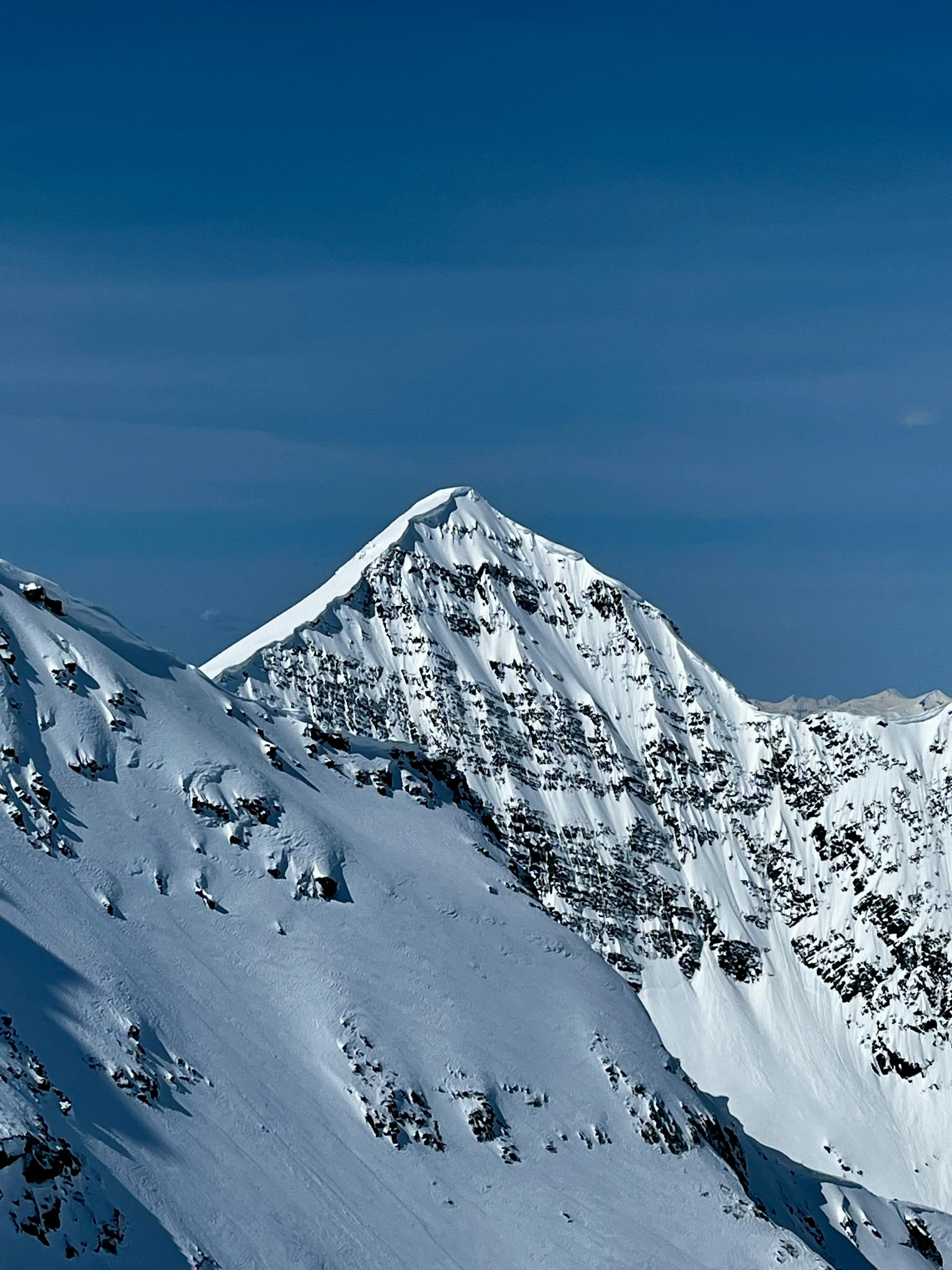 The steep, snow-covered summit and rock face of Lil' Baby above Azure Pass