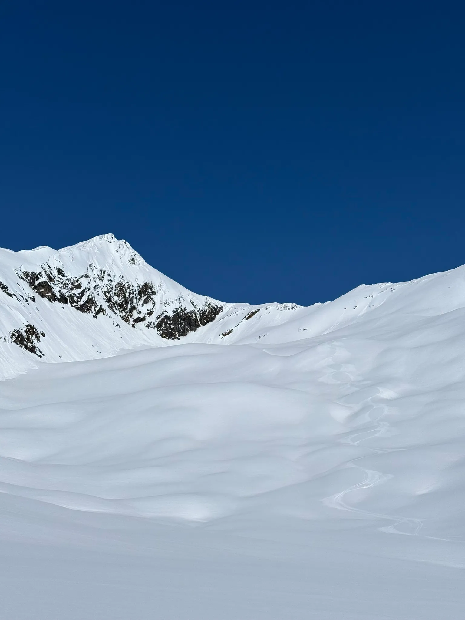The open snow bowl and rocky ridge leading back toward Azure Pass base camp