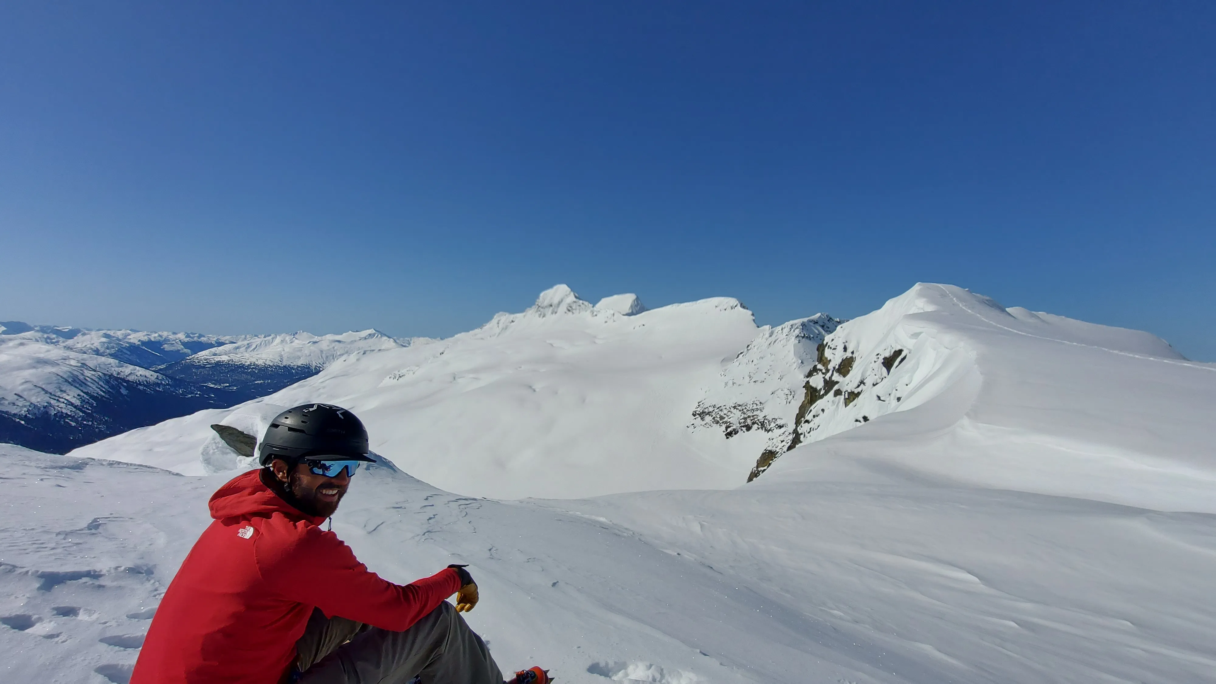 Jordan sitting at the end of the snowy ridge before dropping onto its backside